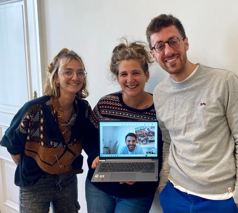 Emma et Jeanne, de la CCL, aux côtés d’Anthony, qui tient un ordinateur portable où Sam apparaît en visioconférence.